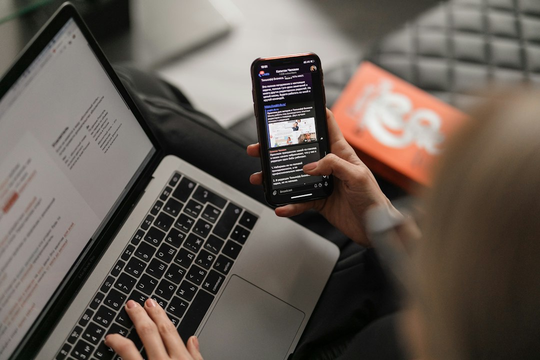 Person using a laptop and smartphone